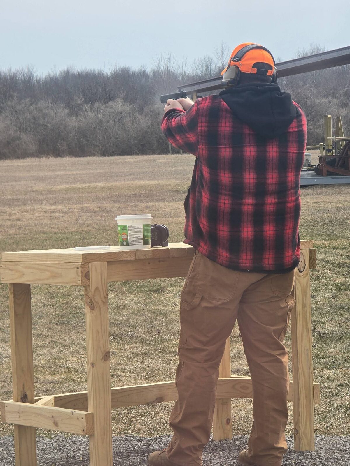 A first-time shooter shouldering a shotgun under supervision at the range